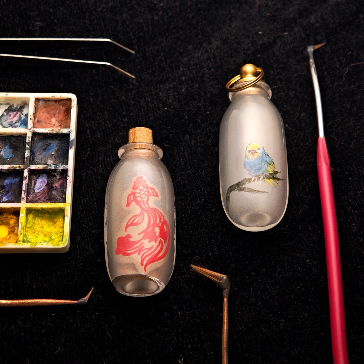 EVERWITHIN worktable with glass vessels, pigments, tweezers, and hooked brushes