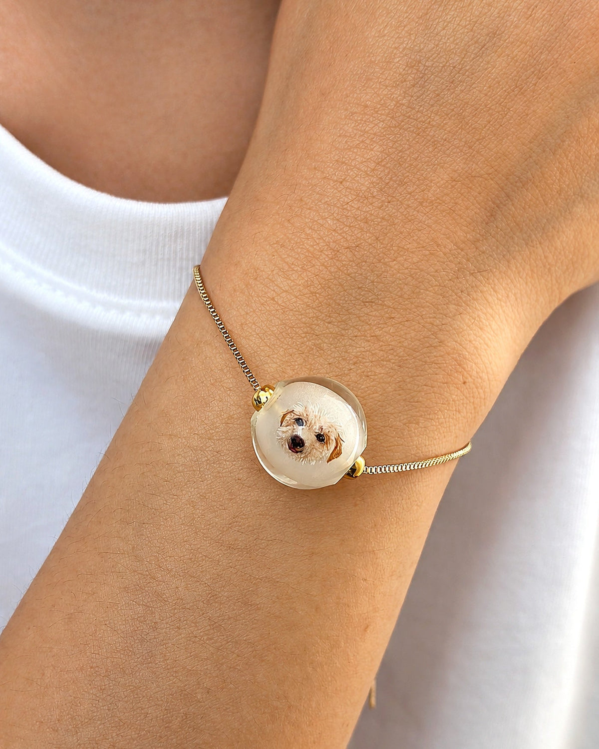 Gold custom pet portrait bracelet worn on a wrist for necklace and bracelet comparison