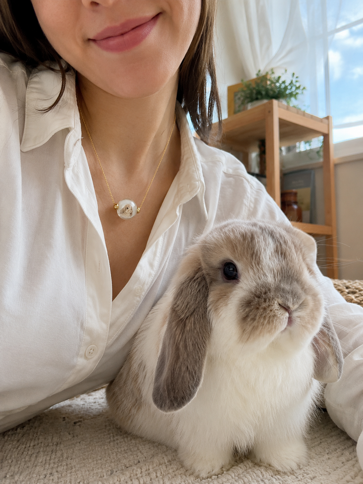 Rabbit beside its custom portrait necklace worn by Ashely Johnson