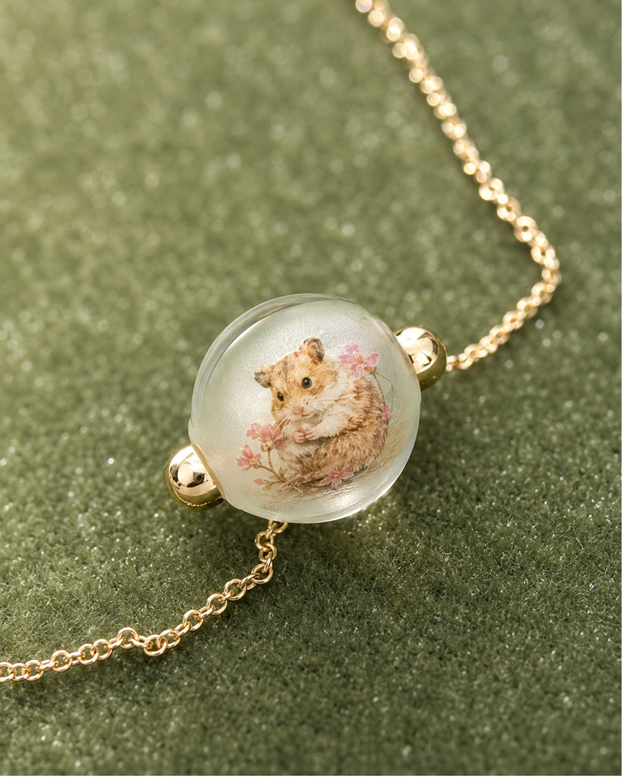 Hand-painted hamster portrait inside a glass necklace bead