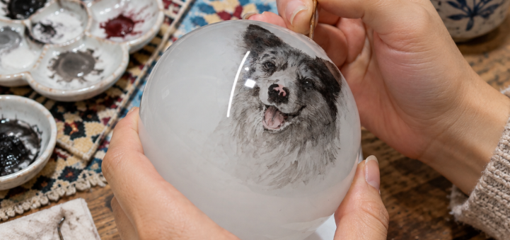 Inside-painted dog portrait taking shape on the inner wall of a glass ornament