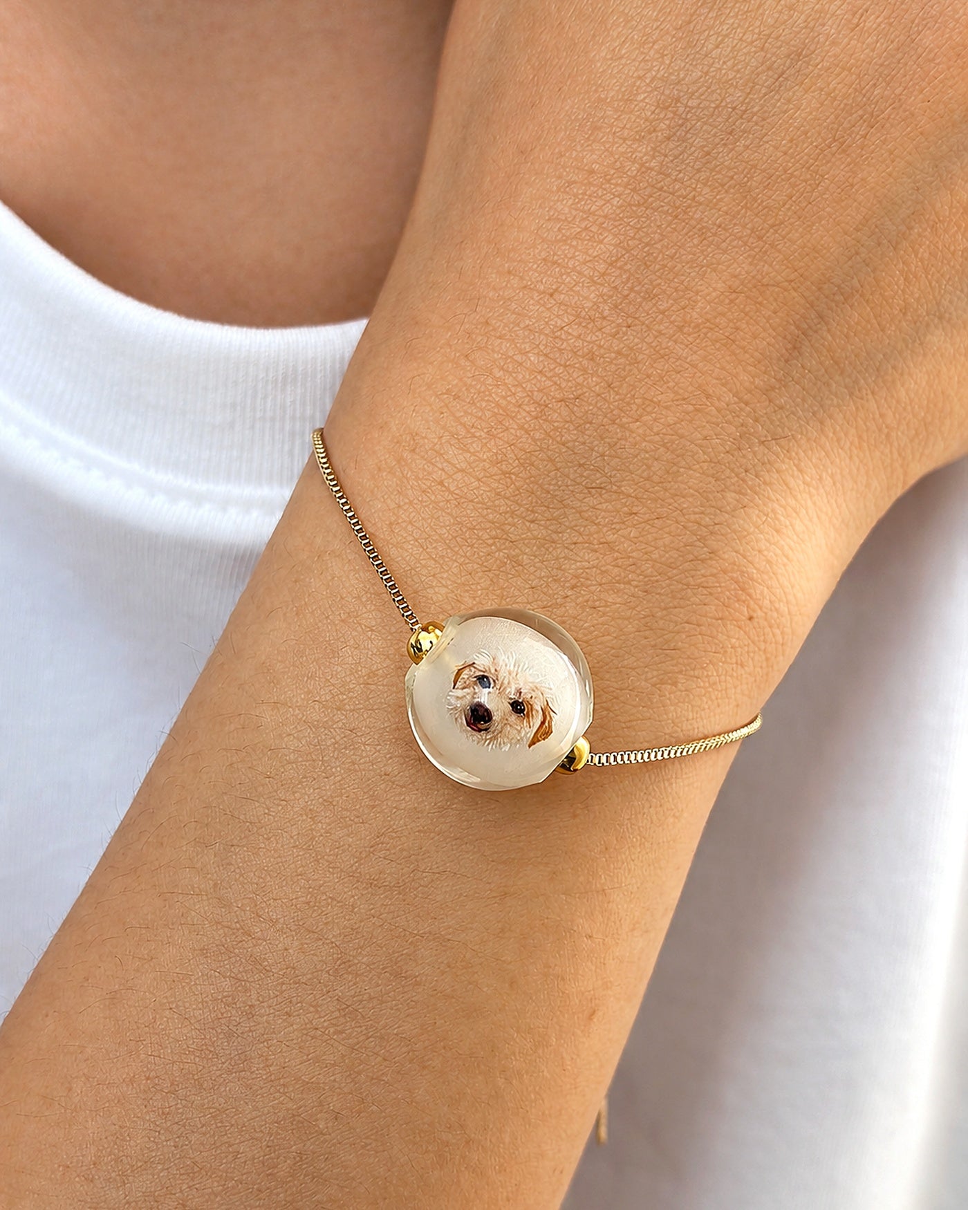 Single gold custom dog portrait bracelet worn on a wrist